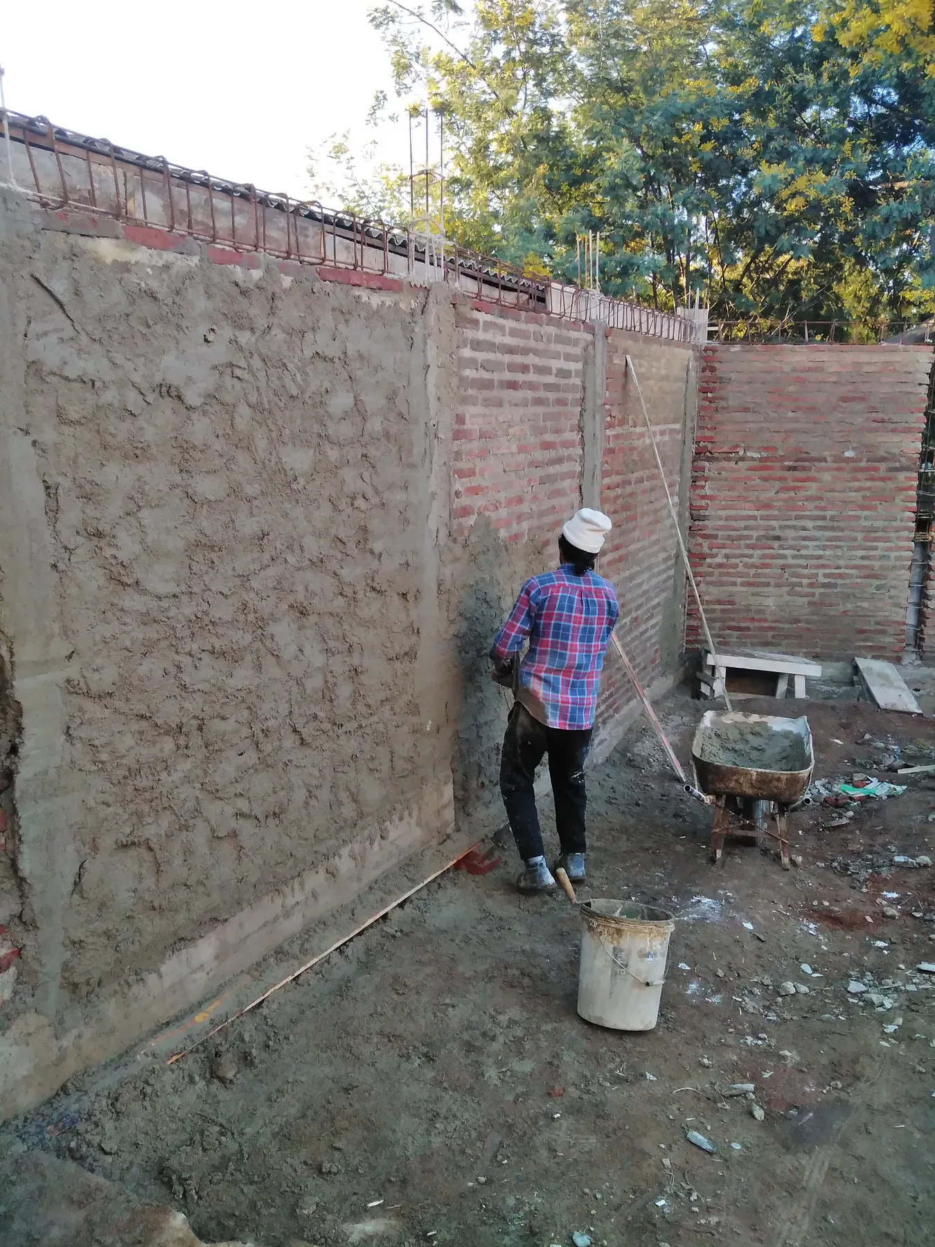 Terminación de albañilería artesanal junto a vegetación existente.