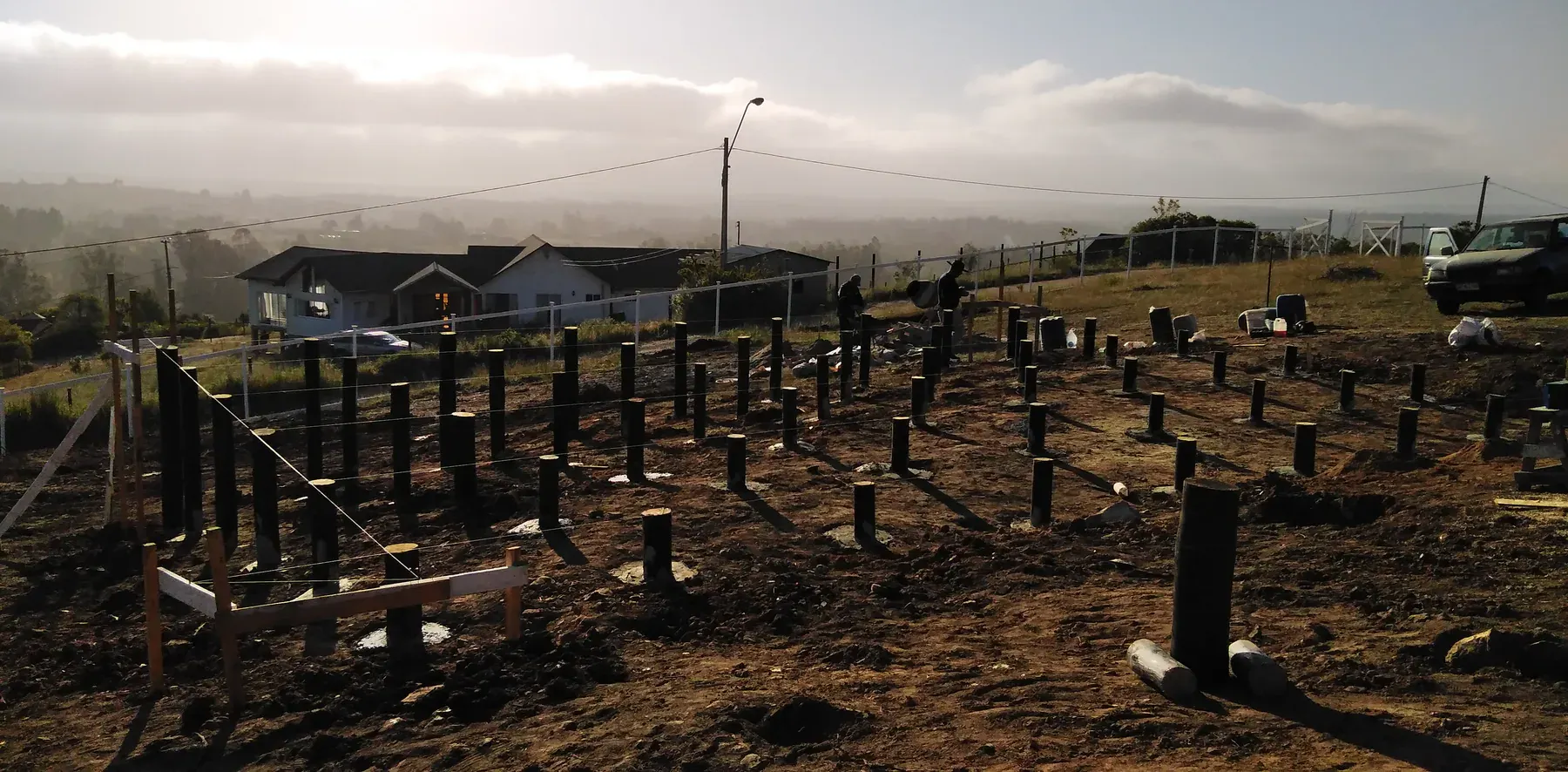 Secuencia de apoyos de fundación sobre el terreno al atardecer.