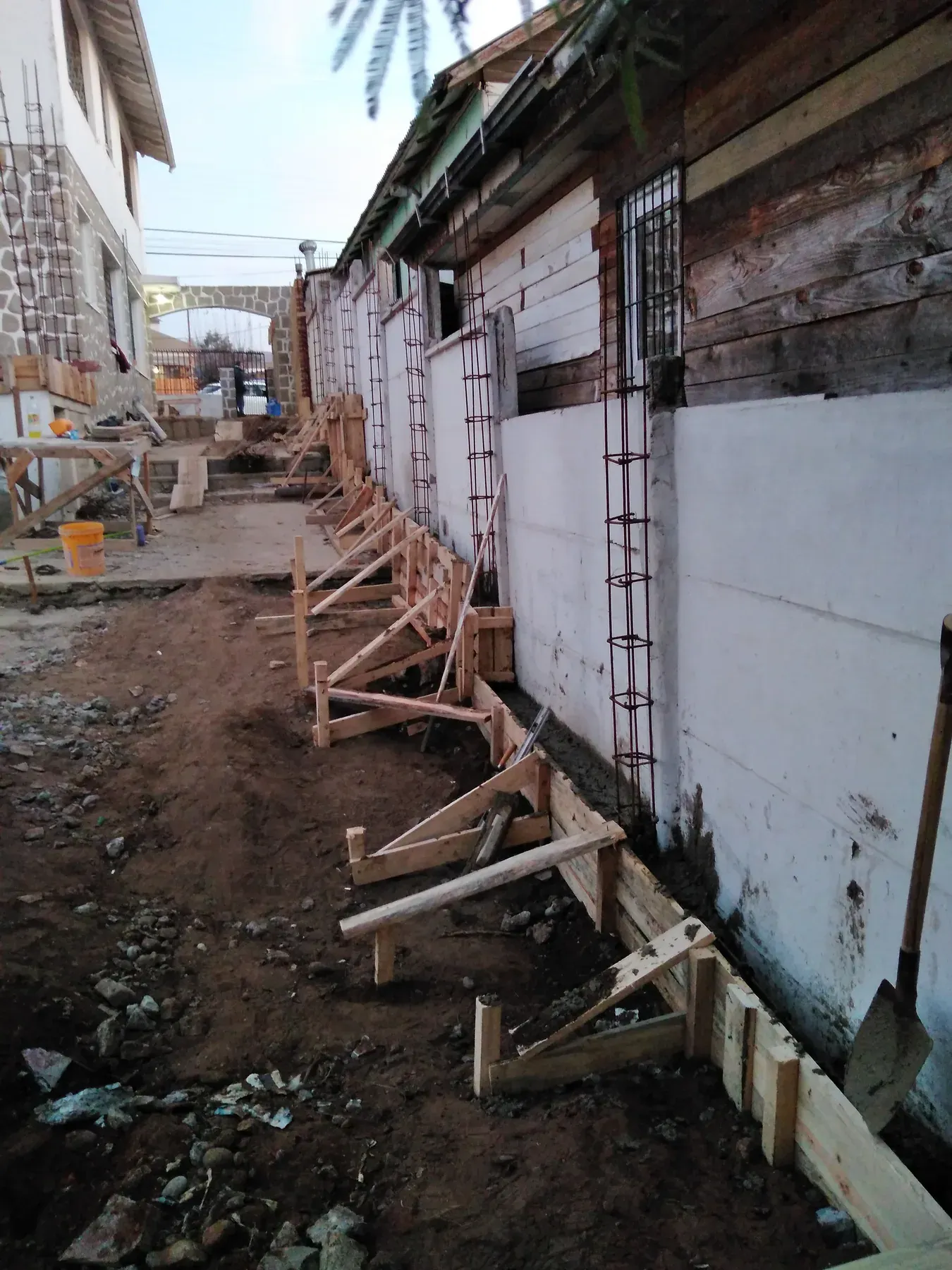 Preparación de un encuentro estructural apuntalado junto a un muro existente.
