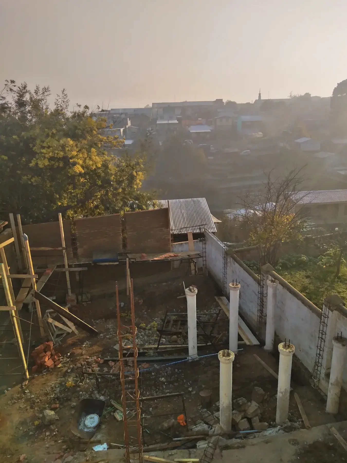 Muros en construcción con pilares y pasadas sanitarias al atardecer.