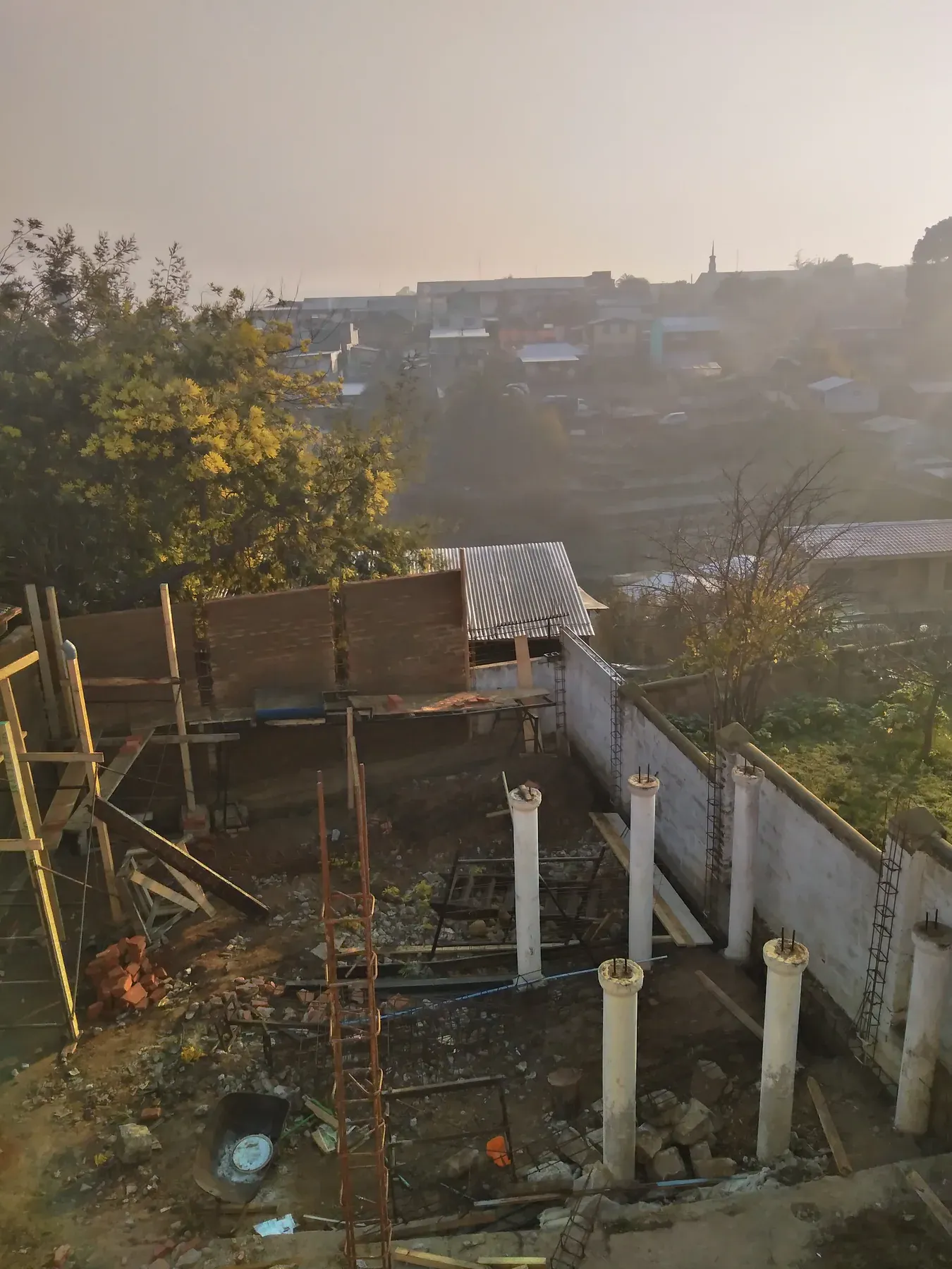 Muros en construcción con pilares y pasadas sanitarias al atardecer.
