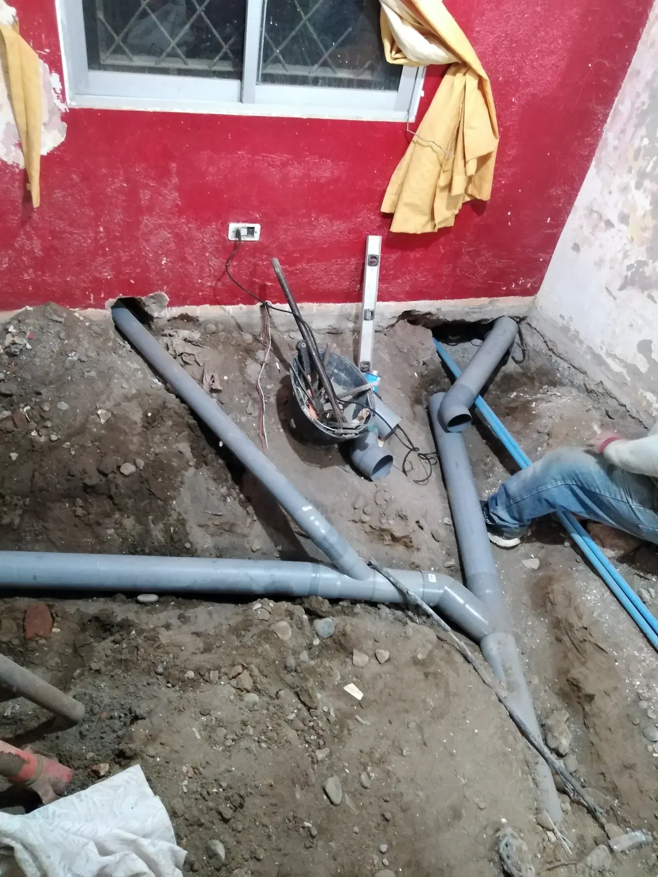 Tuberías sanitarias dispuestas junto a un muro antes de cerrar la obra.