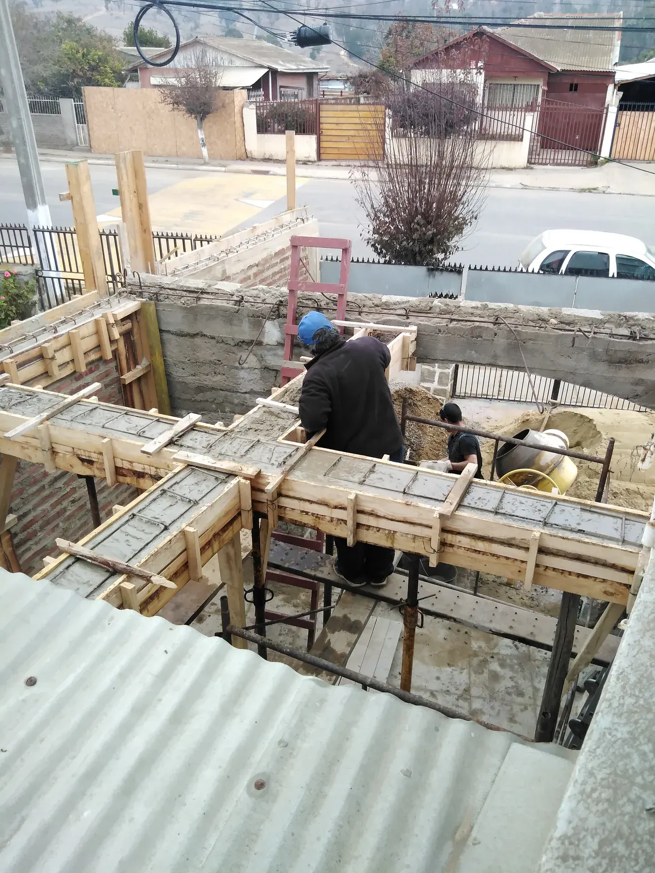Preparación manual del terreno y moldajes en una obra residencial.