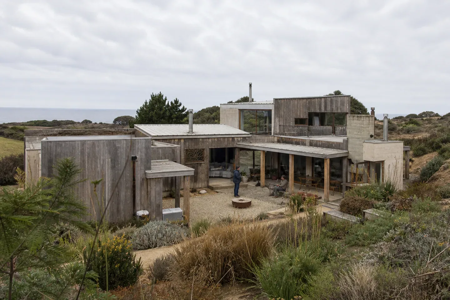 Vivienda de varios volúmenes organizados alrededor de un patio en una ladera costera.